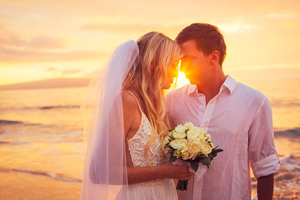 bride and groom embracing on a beach